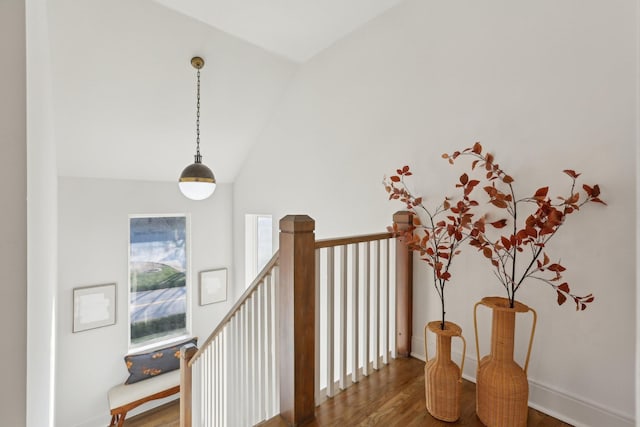 stairway with wood finished floors and lofted ceiling