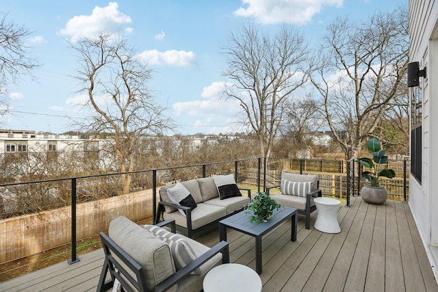wooden terrace with outdoor lounge area and fence