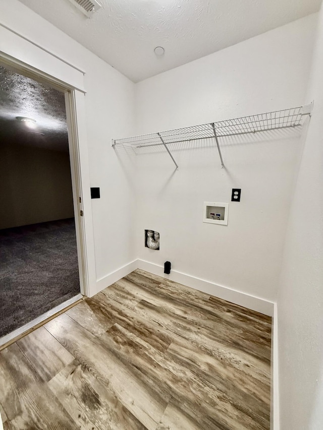 laundry room with washer hookup, laundry area, baseboards, wood finished floors, and visible vents
