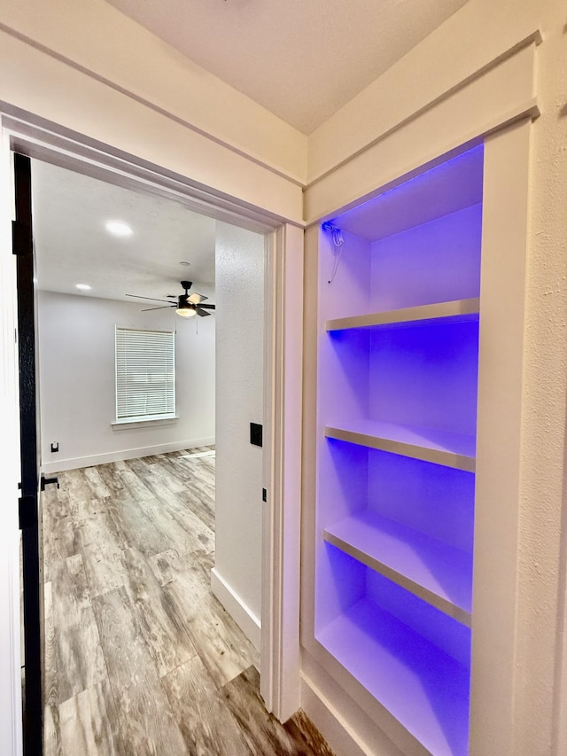 hallway featuring baseboards and wood finished floors