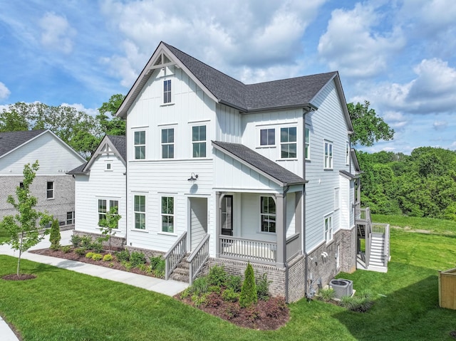 1052 Wetzel Dr, Franklin, TN 37064 - view of front of house with board and batten siding, covered porch, stairway, a front yard, and cooling unit