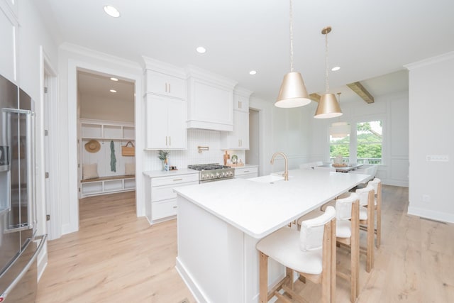 1052 Wetzel Dr, Franklin, TN 37064 - kitchen featuring a sink, light wood-type flooring, a kitchen island with sink, decorative backsplash, and recessed lighting