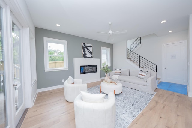 1052 Wetzel Dr, Franklin, TN 37064 - living room with light wood-type flooring, stairs, a glass covered fireplace, recessed lighting, and ceiling fan