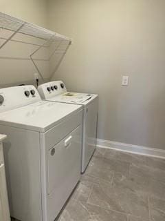 washroom with laundry area, baseboards, and washing machine and dryer
