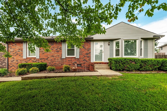 single story home with entry steps, brick siding, and a front yard