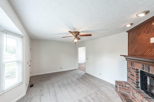 unfurnished living room with visible vents, a ceiling fan, carpet, and baseboards