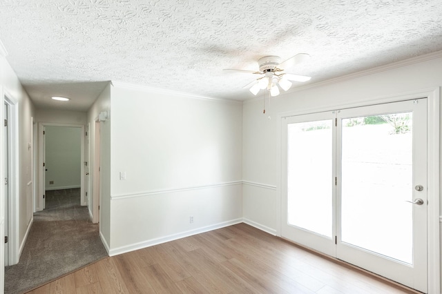 unfurnished room with crown molding, ceiling fan, light wood-type flooring, and a textured ceiling