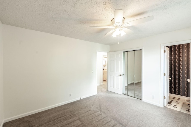 unfurnished bedroom with baseboards, a textured ceiling, carpet floors, and a closet