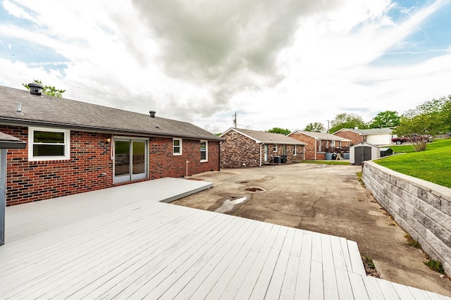 deck featuring a storage shed, an outdoor structure, a patio area, and a residential view