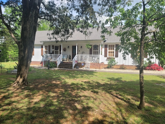 single story home featuring a porch, a front lawn, and board and batten siding