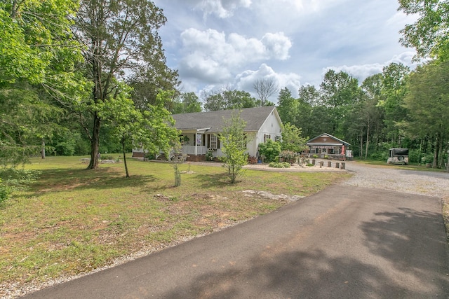 single story home with a porch, aphalt driveway, and a front yard