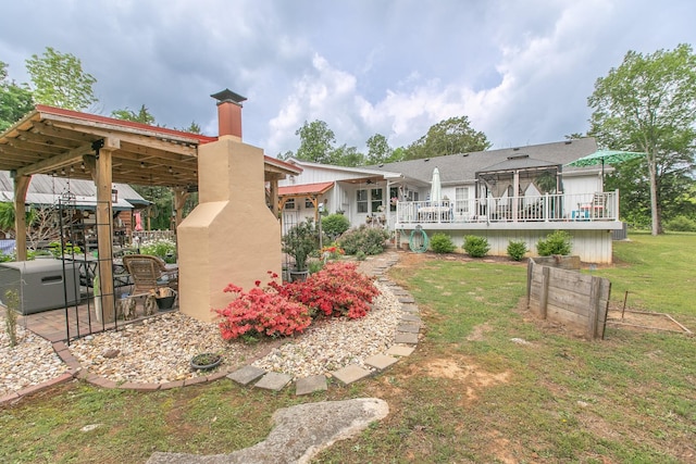 back of property featuring a yard, a chimney, and a deck