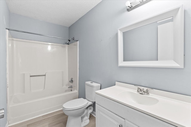 bathroom featuring shower / bath combination, a textured ceiling, wood finished floors, vanity, and toilet