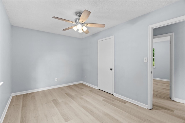 unfurnished bedroom with light wood-style floors, a textured ceiling, baseboards, and ceiling fan