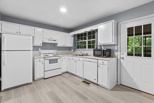 kitchen with light countertops, white cabinetry, under cabinet range hood, and white appliances