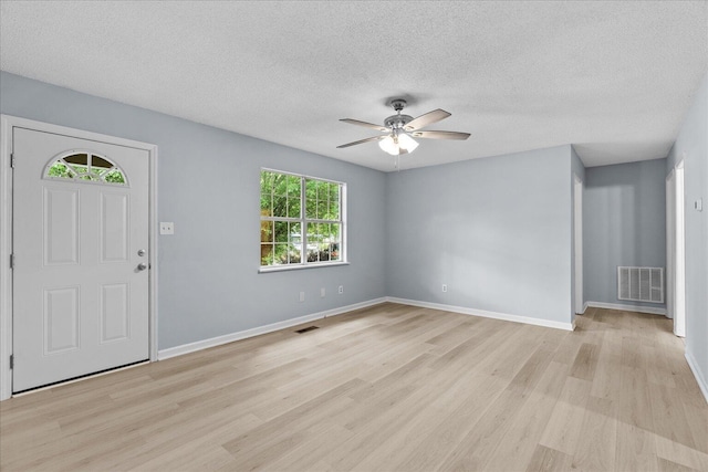 entrance foyer featuring a ceiling fan, light wood-type flooring, a textured ceiling, and visible vents