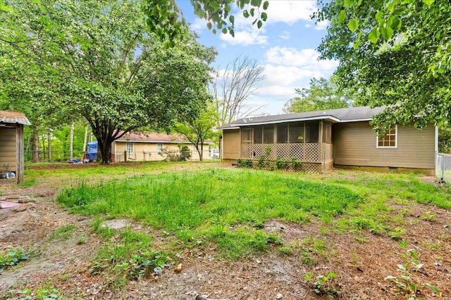 rear view of house featuring a sunroom, fence, and crawl space