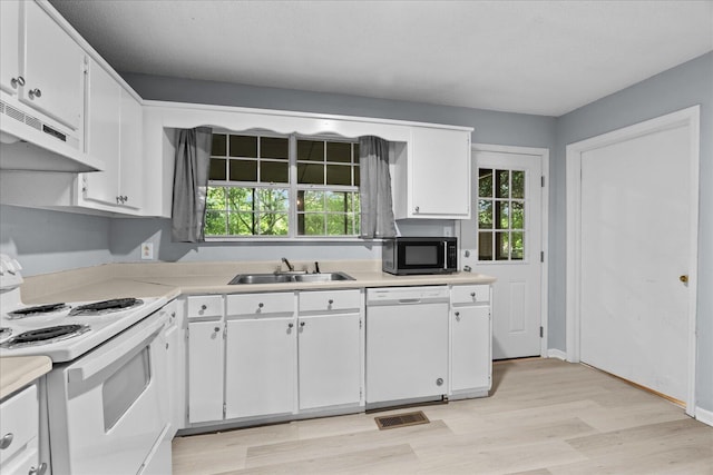 kitchen with a sink, light countertops, white cabinets, under cabinet range hood, and white appliances
