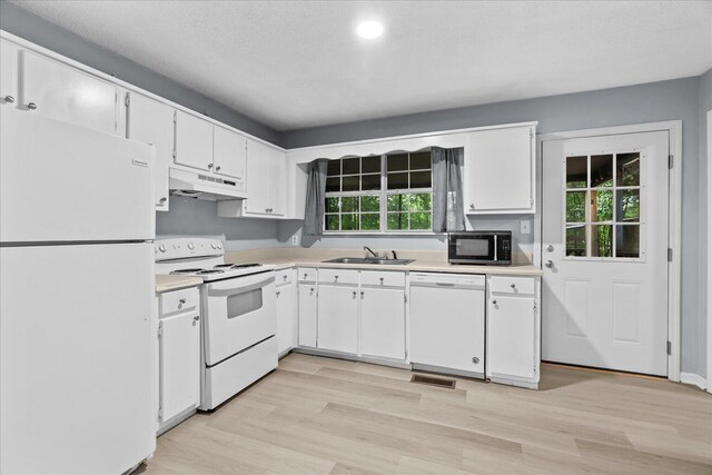kitchen featuring a sink, white appliances, light countertops, white cabinetry, and under cabinet range hood