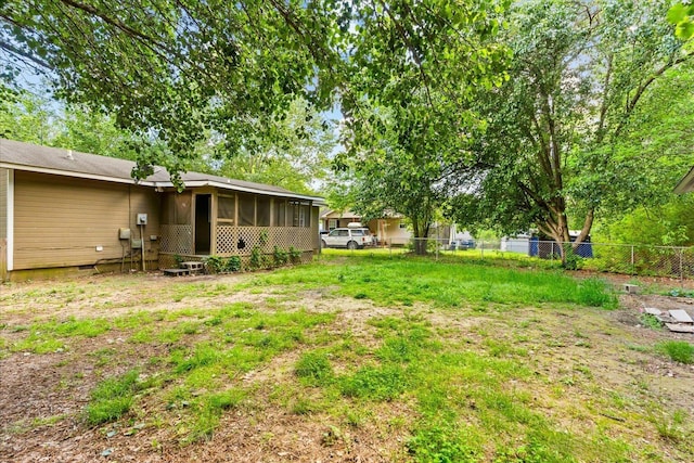 view of yard with a sunroom and fence