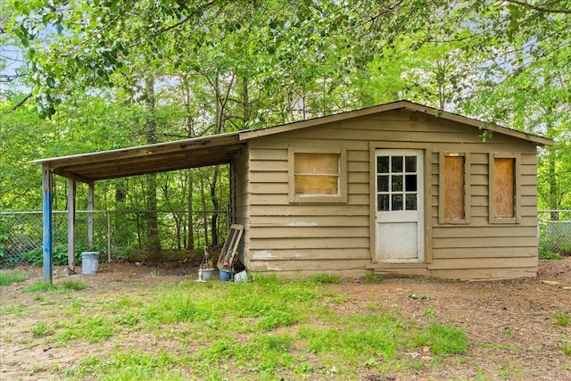 view of outbuilding with fence and an outbuilding
