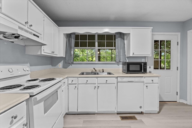 kitchen featuring a sink, under cabinet range hood, white appliances, and light countertops
