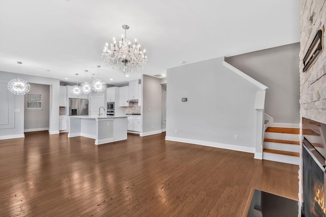 4284 Stone Hall Blvd, Hermitage, TN 37076 - unfurnished living room featuring baseboards, dark wood-type flooring, recessed lighting, a sink, and a notable chandelier