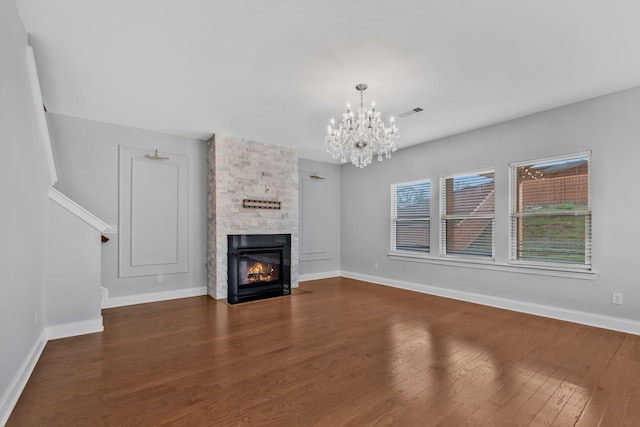 4284 Stone Hall Blvd, Hermitage, TN 37076 - unfurnished living room featuring a chandelier, baseboards, dark wood finished floors, and a stone fireplace
