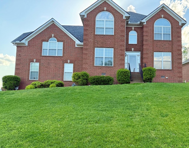 view of front of property featuring brick siding, a shingled roof, a front lawn, and crawl space