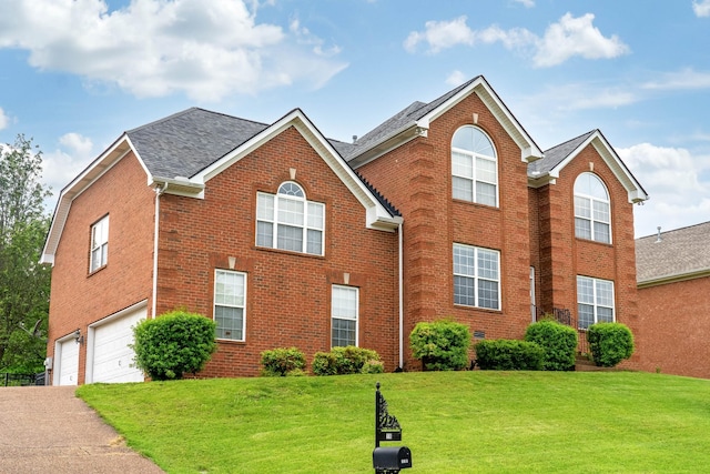 116 N Wynridge Way, Goodlettsville, TN 37072 - view of front of property with brick siding, a garage, driveway, a front yard, and roof with shingles