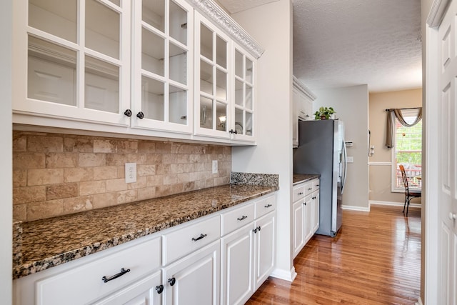 116 N Wynridge Way, Goodlettsville, TN 37072 - kitchen featuring freestanding refrigerator, light wood-type flooring, decorative backsplash, baseboards, and white cabinets