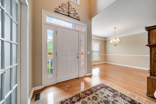 116 N Wynridge Way, Goodlettsville, TN 37072 - foyer with light wood finished floors, a chandelier, ornamental molding, a textured ceiling, and baseboards
