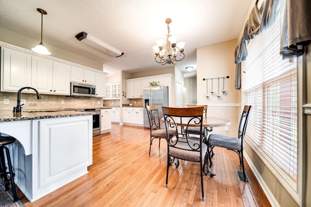 116 N Wynridge Way, Goodlettsville, TN 37072 - kitchen with stainless steel appliances, a sink, a chandelier, white cabinetry, and tasteful backsplash