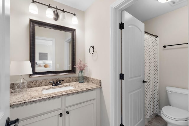 full bath with vanity, toilet, and visible vents