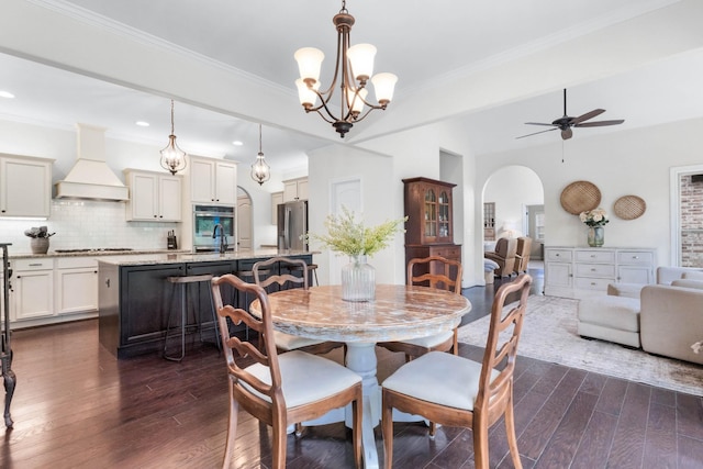 dining room with recessed lighting, arched walkways, ceiling fan with notable chandelier, and dark wood-style floors