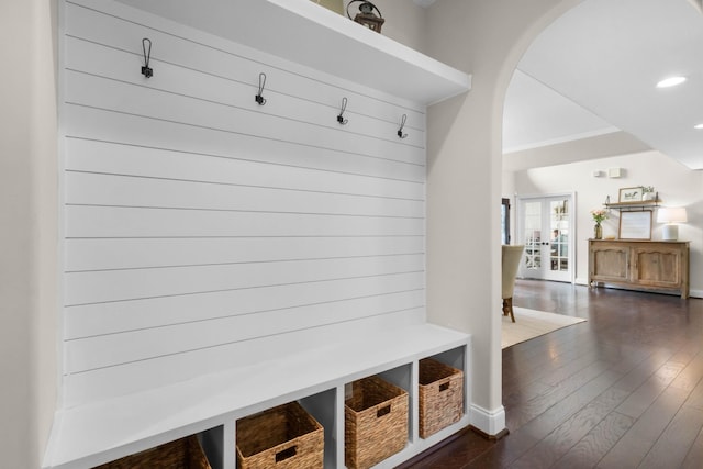 mudroom featuring arched walkways, baseboards, french doors, and dark wood-type flooring