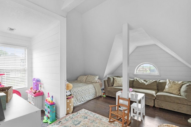 bedroom featuring wooden walls, visible vents, and wood finished floors