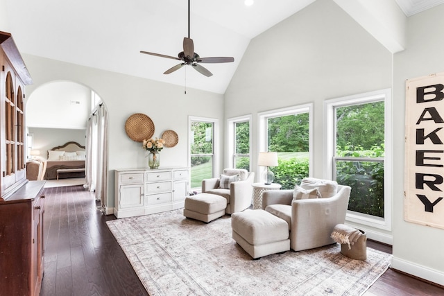sitting room with plenty of natural light, dark wood finished floors, ceiling fan, and high vaulted ceiling