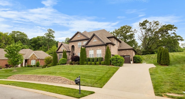 view of front of home featuring brick siding, a front lawn, and concrete driveway