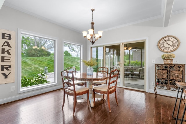 dining space featuring baseboards, ornamental molding, dark wood finished floors, and a notable chandelier