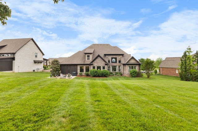 rear view of property with a sunroom, a yard, and brick siding