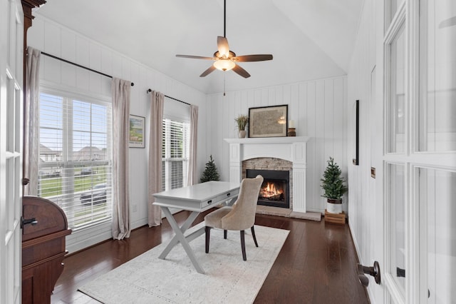 office area with a ceiling fan, dark wood-style floors, lofted ceiling, and a fireplace