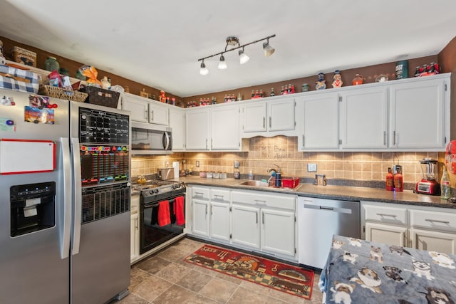 kitchen with white cabinets, appliances with stainless steel finishes, decorative backsplash, and a sink