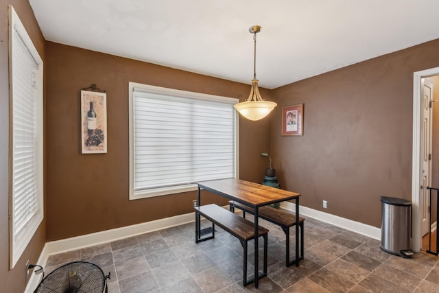 dining room featuring baseboards and stone finish flooring