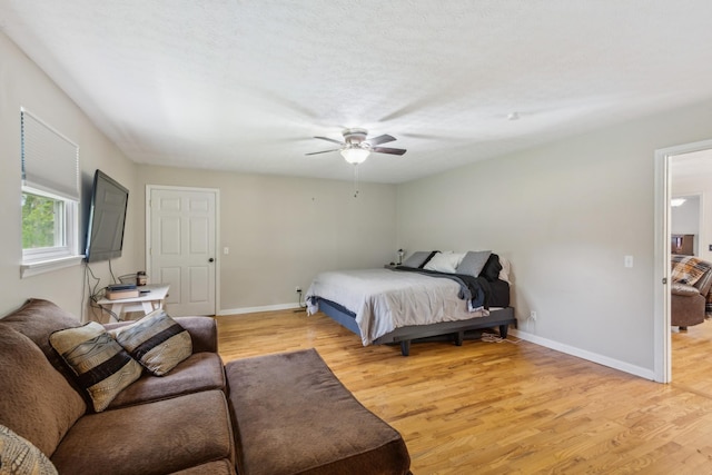 bedroom with baseboards, a ceiling fan, and light wood-style flooring
