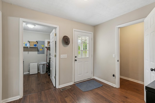 entryway featuring dark wood-type flooring, baseboards, electric panel, and visible vents