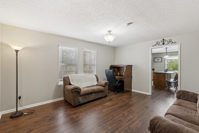 living room with a textured ceiling, baseboards, and hardwood / wood-style floors