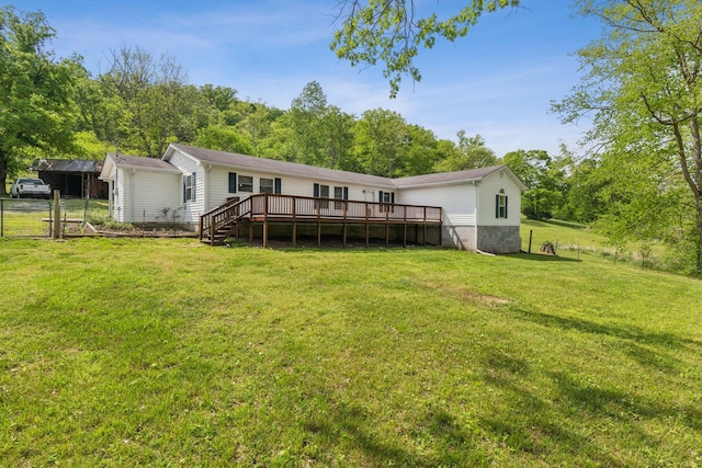 rear view of property with a lawn, a gate, fence, and a deck