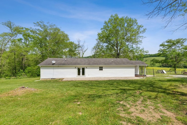 rear view of property with a lawn, a patio, and french doors