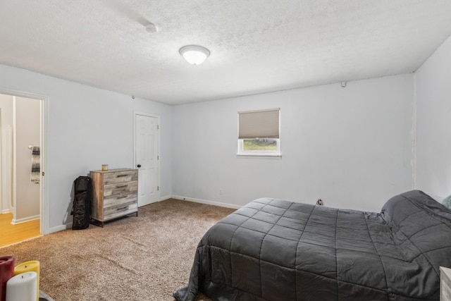 bedroom with carpet floors, a textured ceiling, and baseboards